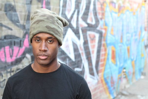 close-up portrait of handsome young african american man in black t-shirt and hat on street - Fotografie, Obrázek