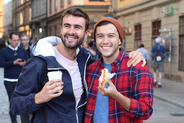 Schönes homosexuelles Paar schlendert durch die Straßen der Stadt - Foto, Bild