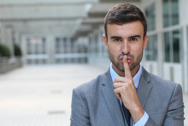 Homme utilisant un signe du doigt pour demander à quelqu'un de garder le silence
 - Photo, image