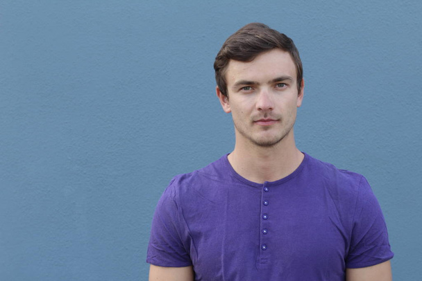 portrait en gros plan d'un beau jeune homme en chemise violette devant un mur bleu
 - Photo, image