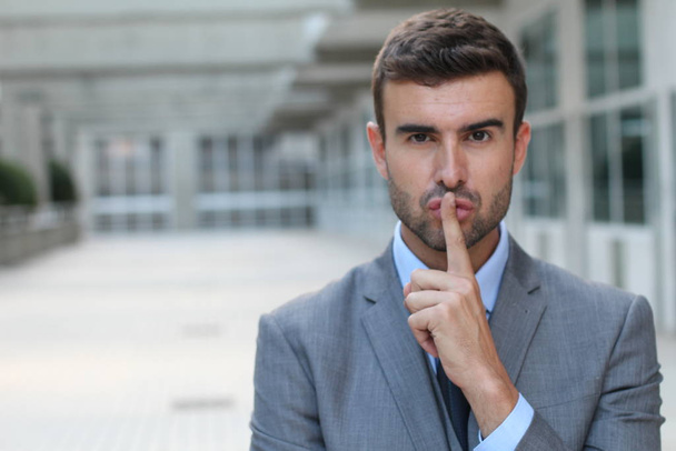 Άνθρωπος που χρησιμοποιεί ένα σημάδι δακτύλου για να ζητήσει από κάποιον να παραμείνει σιωπηλός - Φωτογραφία, εικόνα