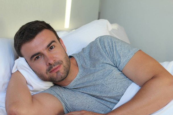 Relaks patrząc mężczyzna przytulny w łóżku - Zdjęcie, obraz