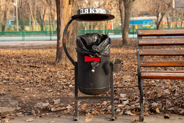 ドニエプル市の秋のベンチの近くの公園のゴミ箱ウクライナ - 写真・画像