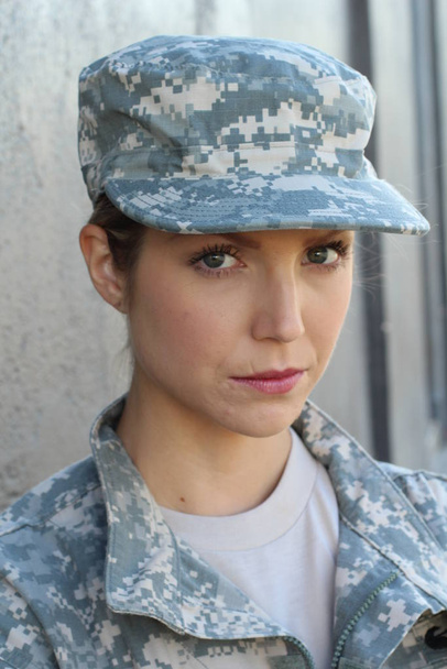 Gorgeous young woman in a Military costume on gray background - Foto, Bild