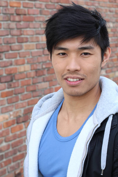 primer plano retrato de guapo joven asiático hombre en frente de ladrillo pared
 - Foto, Imagen