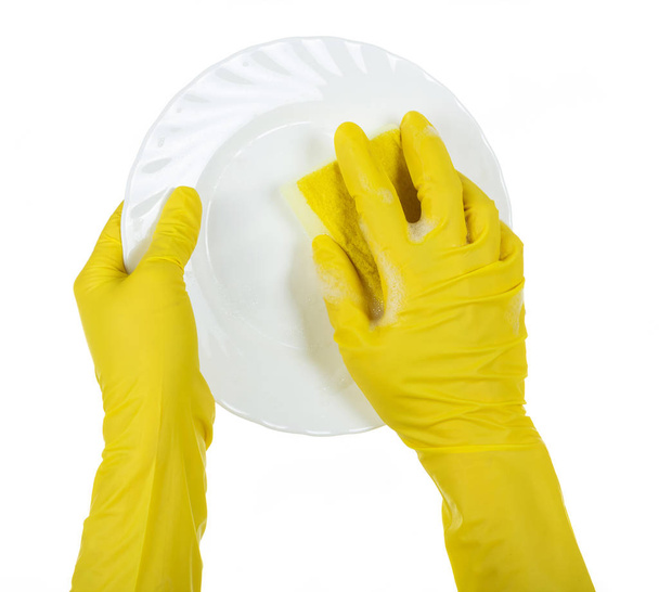 Hands in yellow gloves wash white ceramic plate isolated on white - Foto, imagen