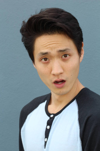 Aziatische man met neutrale expressie close-up - Foto, afbeelding