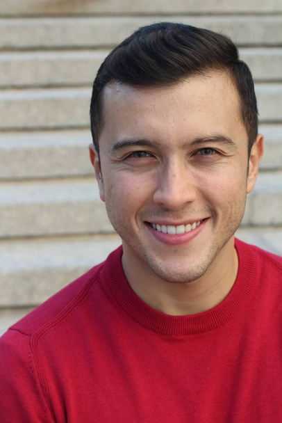 close-up portret van knappe jongeman in rood sweatshirt op straat - Foto, afbeelding
