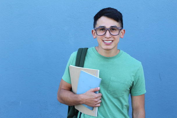 primer plano retrato de joven estudiante guapo con mochila en frente de la pared azul
 - Foto, imagen
