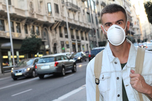 close-up portrait of handsome young man in medical safety mask on street - Photo, Image