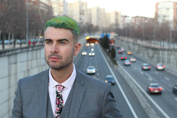 Eleganter gutaussehender Mann mit grünen Haaren in der Stadt - Foto, Bild