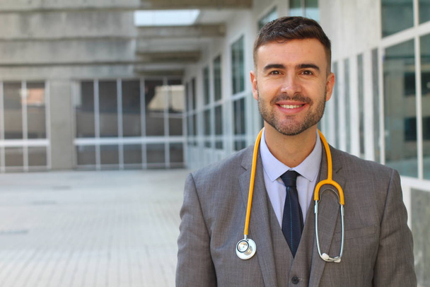 close-up portrait of handsome young businessman with stethoscope on street - Photo, Image