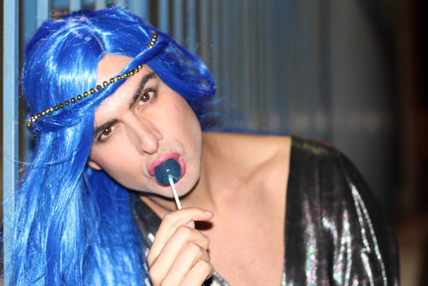 κοντινό πορτρέτο της νεαρής τρανσέξουαλ με μπλε μαλλιά και γλειφιτζούρι στο δρόμο  - Φωτογραφία, εικόνα