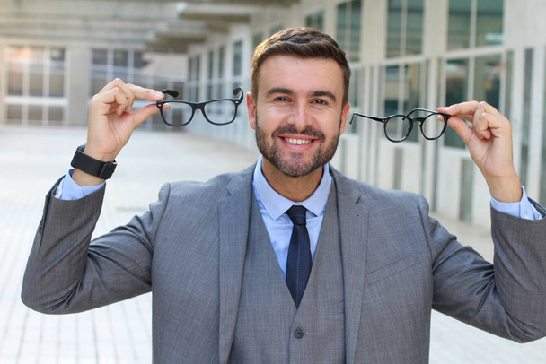 close-up portrait of handsome young businessman with eyeglasses showing excited expression on street - Фото, изображение