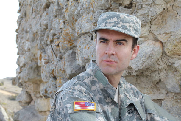 Terve amerikkalainen sotilas hymyilee ulkona.
 - Valokuva, kuva