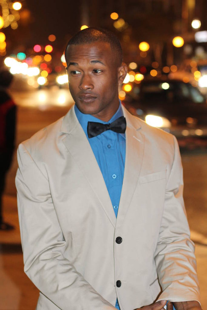 κοντινό πορτραίτο όμορφου νεαρού επιχειρηματία με μπεζ κοστούμι και παπιγιόν στο δρόμο τη νύχτα - Φωτογραφία, εικόνα