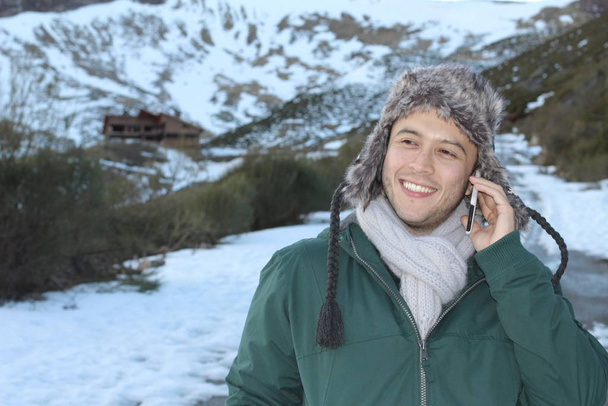 Eskimo man glimlachen tijdens het bellen via de telefoon - Foto, afbeelding