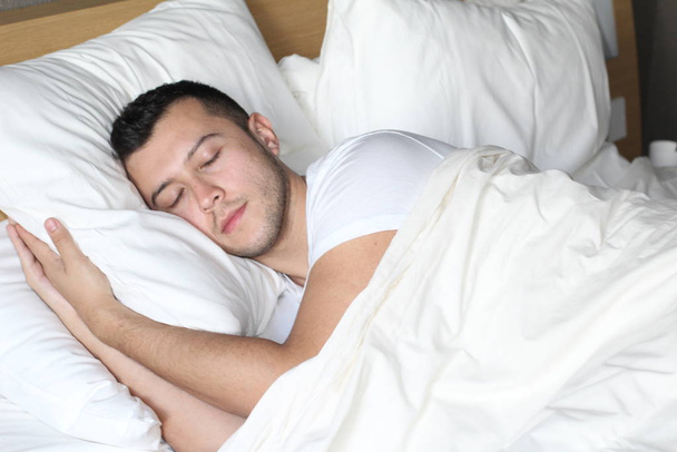 L'homme ethnique a profondément dormi dans un lit confortable
 - Photo, image