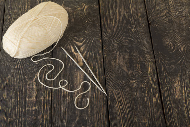 Tangle of white wool yarn on a beautiful dark wooden background - Foto, immagini