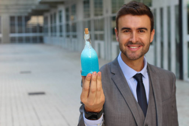lähikuva muotokuva komea nuori liikemies tilalla pullo sinistä juomaa kadulla
 - Valokuva, kuva