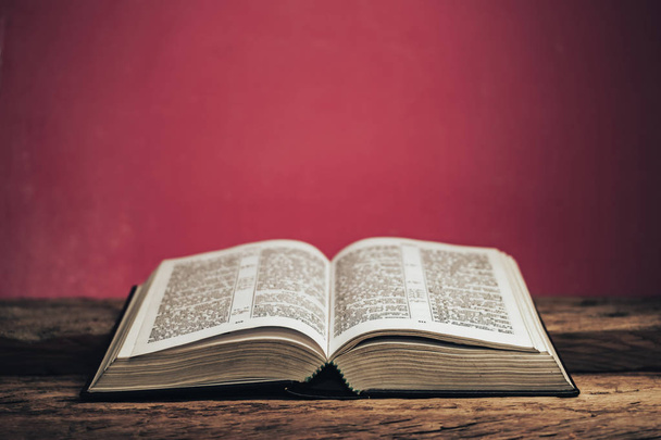 Biblia aberta em uma mesa de madeira de carvalho velho. Bela parede verde fundo
. - Foto, Imagem