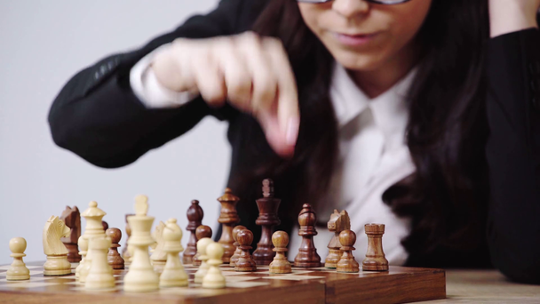 vista recortada de la mujer de negocios elegir figura en el tablero de ajedrez
  - Imágenes, Vídeo