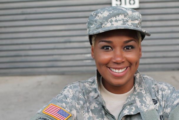 Afrikkalainen amerikkalainen nainen sotilas seisoo ulkona päivällä
 - Valokuva, kuva