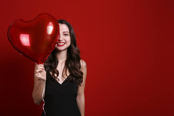 Beautiful female holding floating balloons for st. valentine's day holiday. - Foto, afbeelding