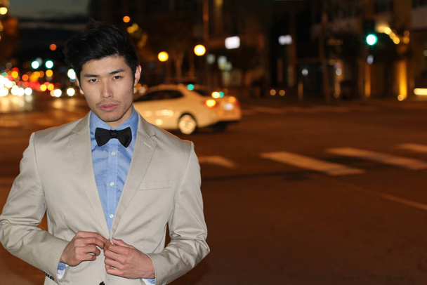 primer plano retrato de guapo joven asiático hombre en beige chaqueta en la calle por la noche
 - Foto, Imagen