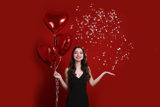 Beautiful female holding floating balloons for st. valentine's day holiday. - Fotó, kép