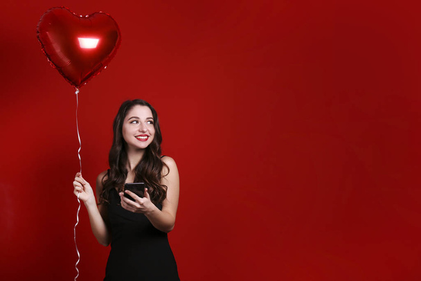 Beautiful female holding floating balloons for st. valentine's day holiday. - Foto, imagen