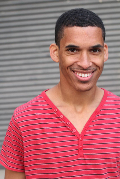 közeli kép egy jóképű, fiatal afro-amerikai férfiról piros pólóban a szürke fal előtt - Fotó, kép