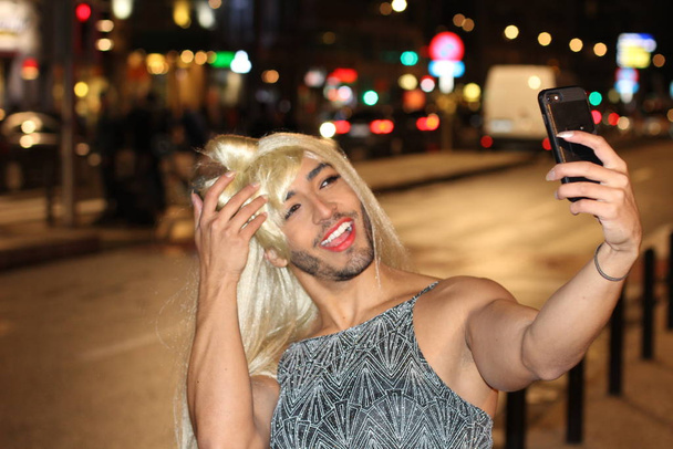 Porträt einer Transgender-Frau, die nachts ein Selfie auf der Straße macht - Foto, Bild