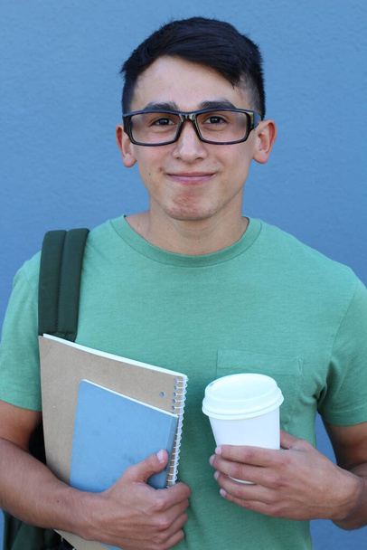 lähikuva muotokuva komea nuori opiskelija reppu edessä sininen seinä
 - Valokuva, kuva