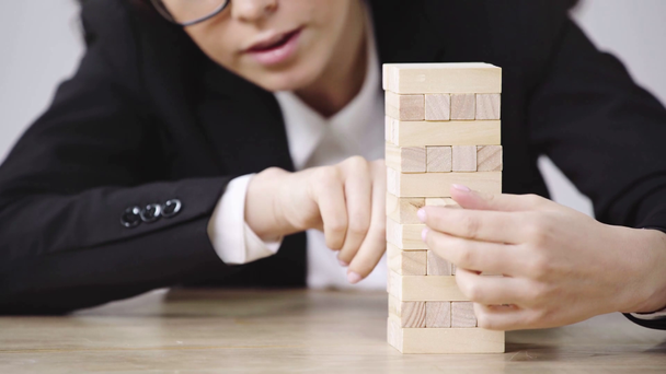 vista ritagliata di donna d'affari che gioca blocchi di legno gioco
  - Filmati, video