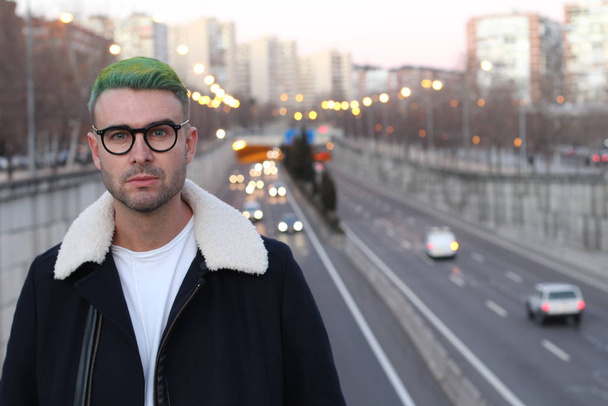 Трендсеттер с зелеными волосами улыбается, размытый городской фон
  - Фото, изображение