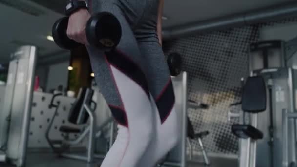 Handheld weergave van vrouwelijke atleet uit te werken met halter. Neergeschoten met Red helium camera in 8k - Video