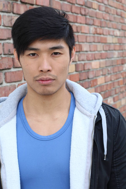 primer plano retrato de guapo joven asiático hombre en frente de ladrillo pared
 - Foto, imagen