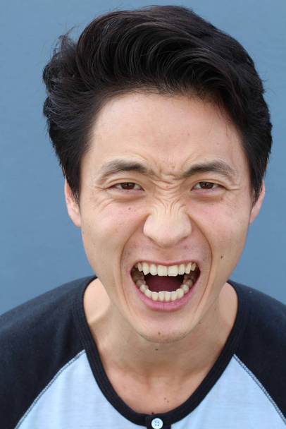 Aziatische man met neutrale expressie close-up - Foto, afbeelding