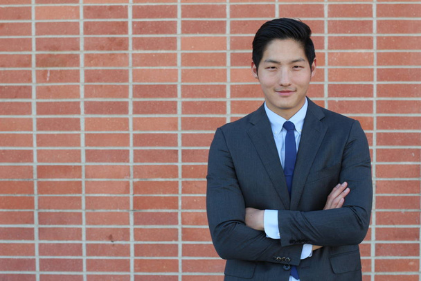 close-up portrait of handsome young asian businessman in front of brick wall - Photo, Image