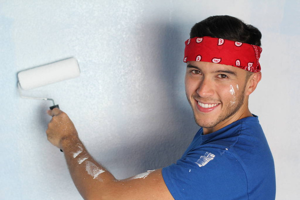 Joyful macho étnico prestes a pintar uma parede em sua casa
 - Foto, Imagem
