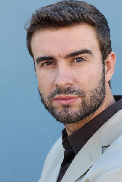 close-up portrait of handsome young bearded man in front of wall - Photo, image