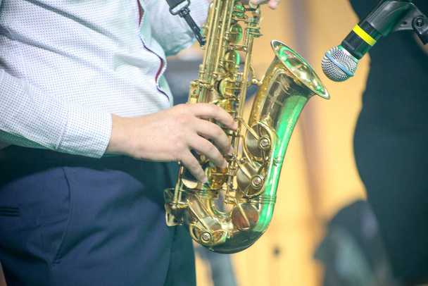 un homme joue du saxophone, un musicien sur scène
 - Photo, image