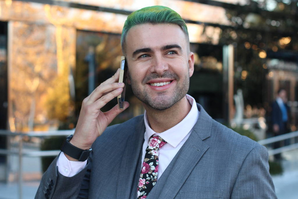 Eleganter gutaussehender Mann mit grünen Haaren telefoniert im Büro - Foto, Bild