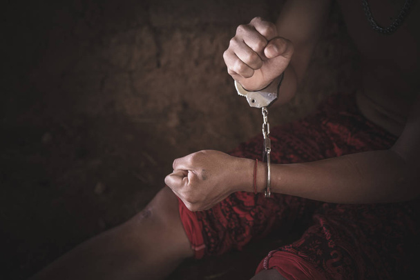 Verzweifelte Menschen sitzen in einer dunklen Zelle. Menschenhandel aufhören - Foto, Bild