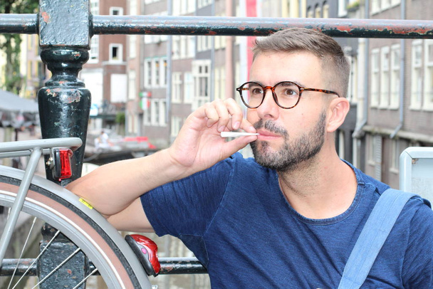 Man smiling in Amsterdam while holding joint - Foto, immagini