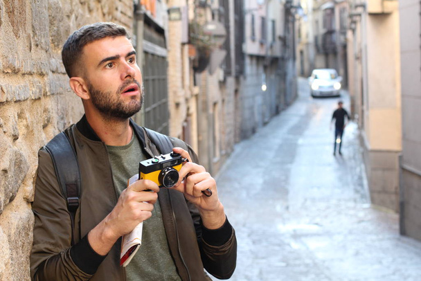 portrait en gros plan de beau jeune homme en chemise avec caméra de film sur la rue de la vieille ville
 - Photo, image