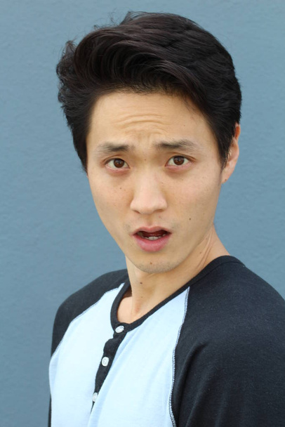 Asian man with neutral expression closeup - Foto, Bild