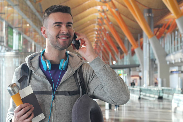Young man getting a call at the airport - Photo, Image