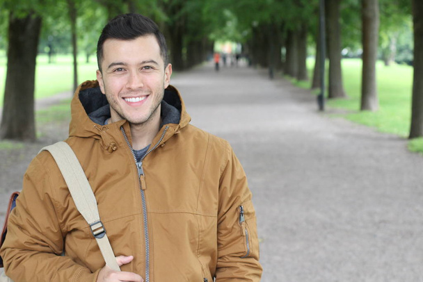 Un homme tendance portant une tenue d'hiver souriante dans le parc - Photo, image